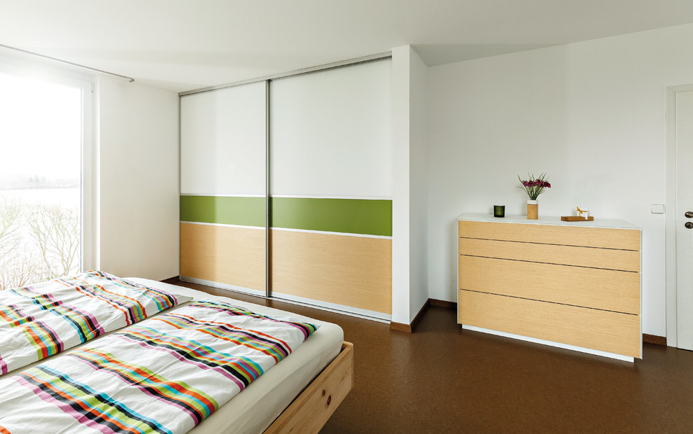 シュトゥットガルトにある広いコンテンポラリースタイルのおしゃれな主寝室 (白い壁、コルクフローリング、茶色い床) のレイアウト