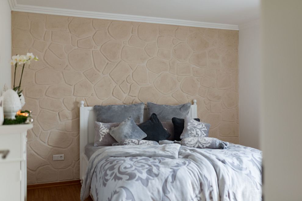 Пример оригинального дизайна: хозяйская спальня с белыми стенами, полом из ламината и коричневым полом