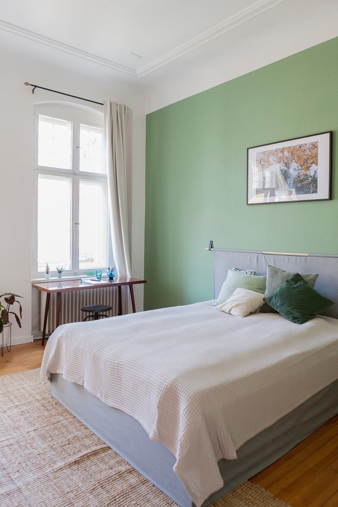 Mittelgroßes Modernes Hauptschlafzimmer ohne Kamin mit weißer Wandfarbe, braunem Holzboden und braunem Boden in Berlin