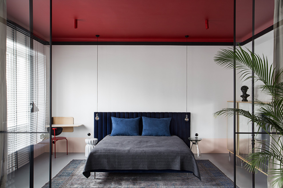 Immagine di una piccola camera da letto design con pareti bianche e pavimento grigio