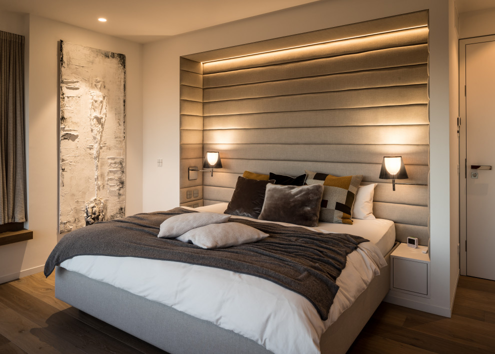 Стильный дизайн: спальня в современном стиле с бежевыми стенами, темным паркетным полом и коричневым полом - последний тренд