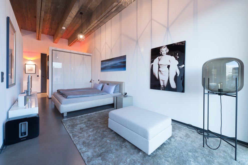 Großes Industrial Schlafzimmer ohne Kamin mit weißer Wandfarbe und grauem Boden in Sonstige
