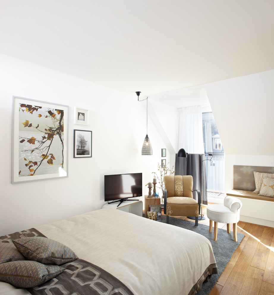 Kleines Modernes Hauptschlafzimmer ohne Kamin mit weißer Wandfarbe und hellem Holzboden in München