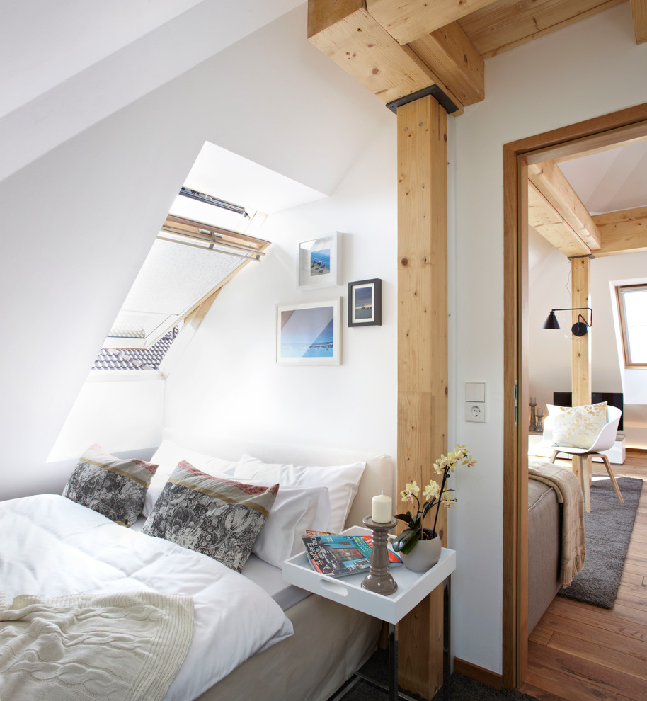 Immagine di un'In mansarda camera degli ospiti contemporanea di medie dimensioni con pareti bianche, pavimento in legno massello medio e nessun camino