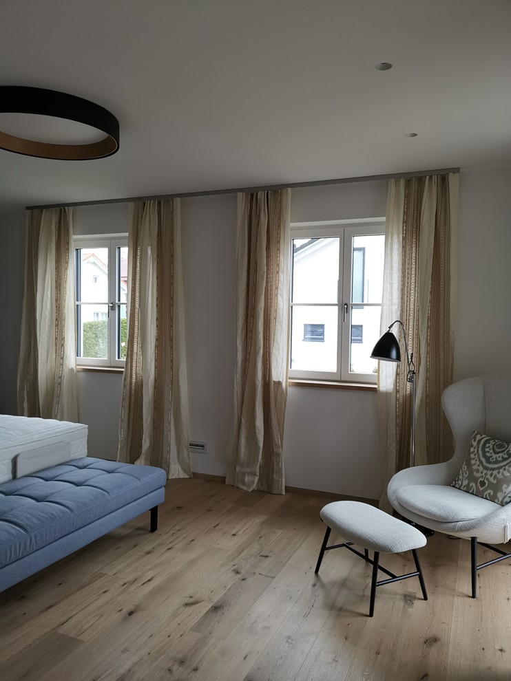 Mittelgroßes Nordisches Hauptschlafzimmer mit weißer Wandfarbe und hellem Holzboden in München