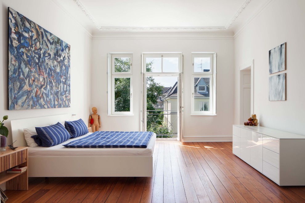 На фото: хозяйская спальня среднего размера в современном стиле с белыми стенами и паркетным полом среднего тона с