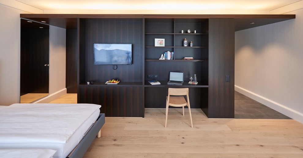 Modelo de dormitorio clásico grande con suelo de madera en tonos medios y suelo beige