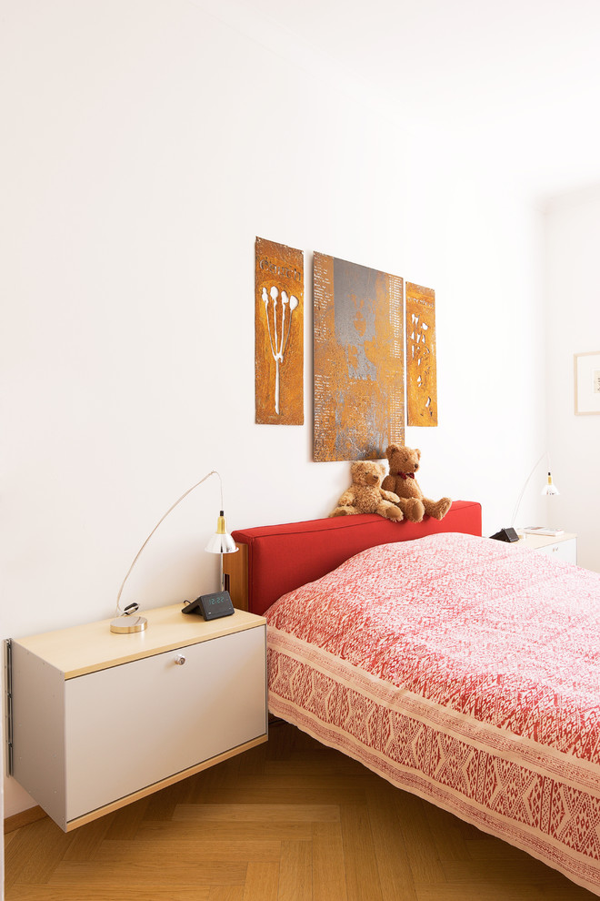 Modelo de dormitorio contemporáneo de tamaño medio sin chimenea con paredes blancas y suelo de madera en tonos medios