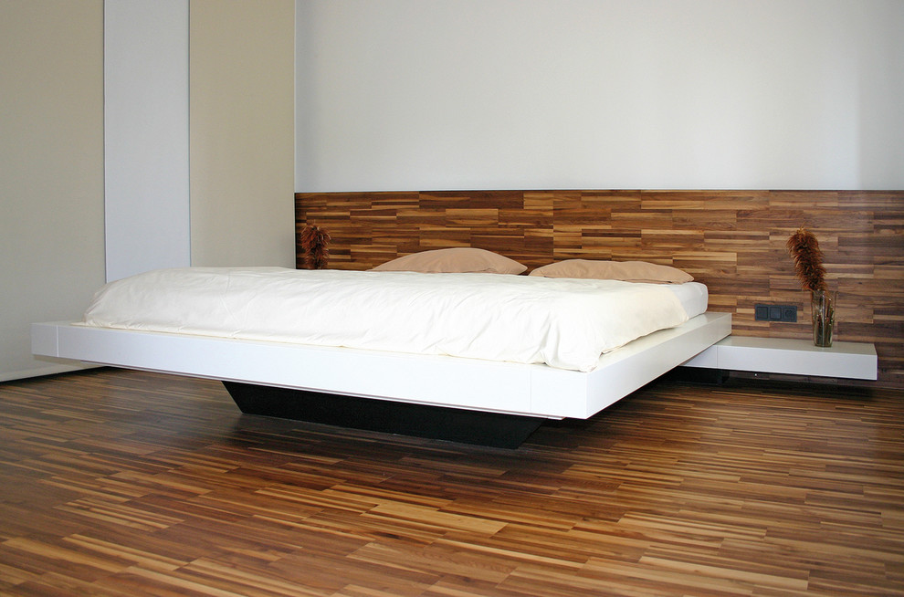 Idéer för att renovera ett sovrum, med vita väggar och mellanmörkt trägolv