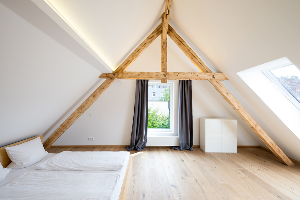 Пример оригинального дизайна: большая спальня на мансарде в скандинавском стиле с белыми стенами и светлым паркетным полом без камина