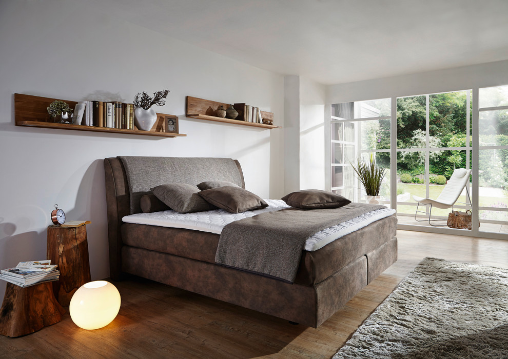 Geräumiges Shabby-Chic Hauptschlafzimmer mit weißer Wandfarbe, Laminat und braunem Boden in Sonstige