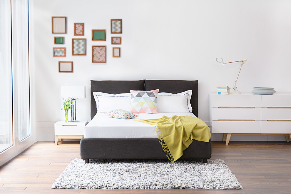 Foto de dormitorio actual sin chimenea con paredes blancas y suelo de madera en tonos medios