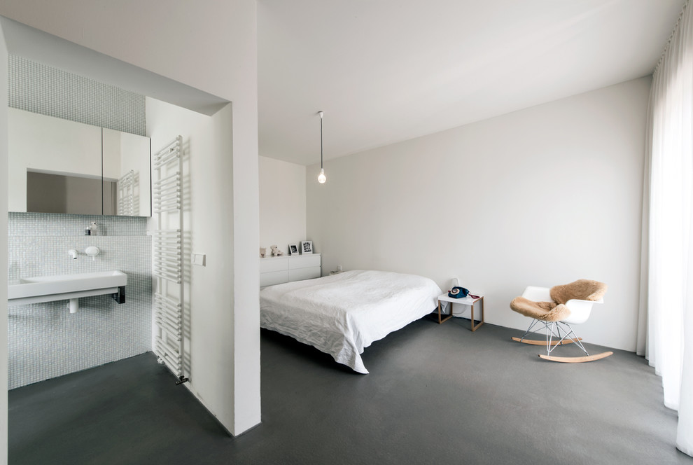 Cette photo montre une chambre moderne de taille moyenne avec un mur blanc et sol en béton ciré.