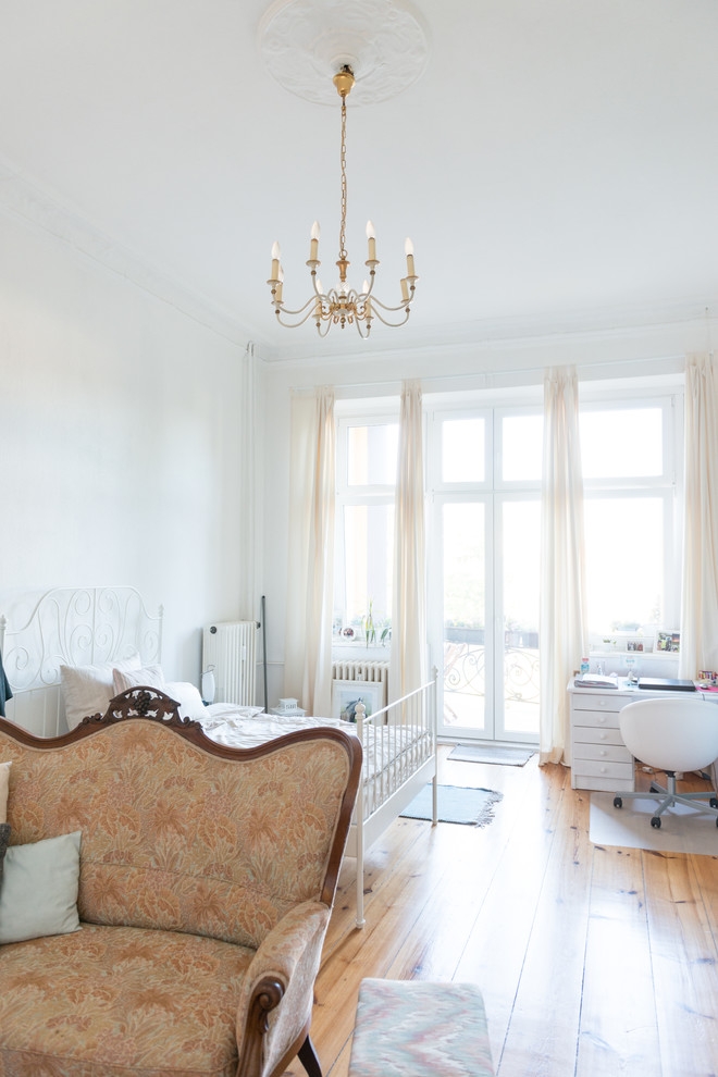 Großes Skandinavisches Hauptschlafzimmer ohne Kamin mit weißer Wandfarbe und braunem Holzboden in Berlin