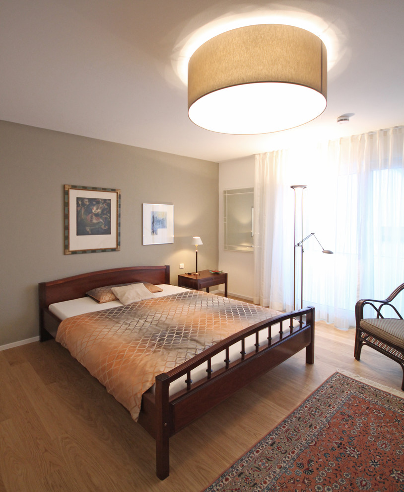 Ejemplo de dormitorio principal vintage de tamaño medio sin chimenea con paredes blancas, suelo de madera en tonos medios y suelo marrón
