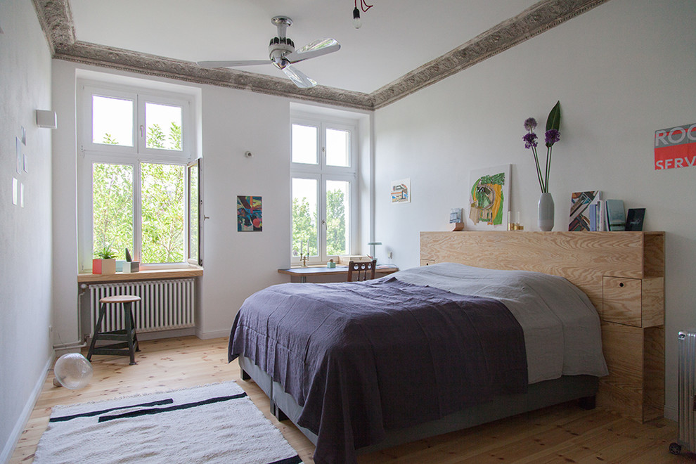 Mittelgroßes Eklektisches Hauptschlafzimmer mit weißer Wandfarbe, hellem Holzboden und braunem Boden in Berlin