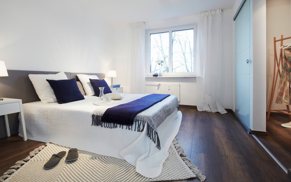 Mittelgroßes Modernes Hauptschlafzimmer ohne Kamin mit weißer Wandfarbe, dunklem Holzboden und braunem Boden in Nürnberg