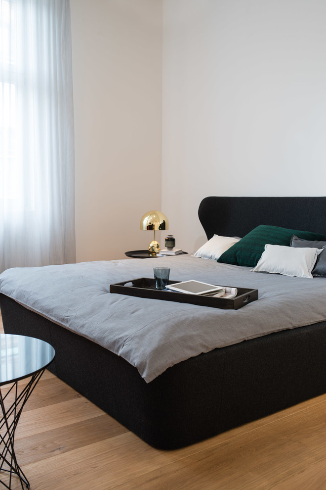 Großes Modernes Hauptschlafzimmer ohne Kamin mit hellem Holzboden, weißer Wandfarbe und beigem Boden in Stuttgart