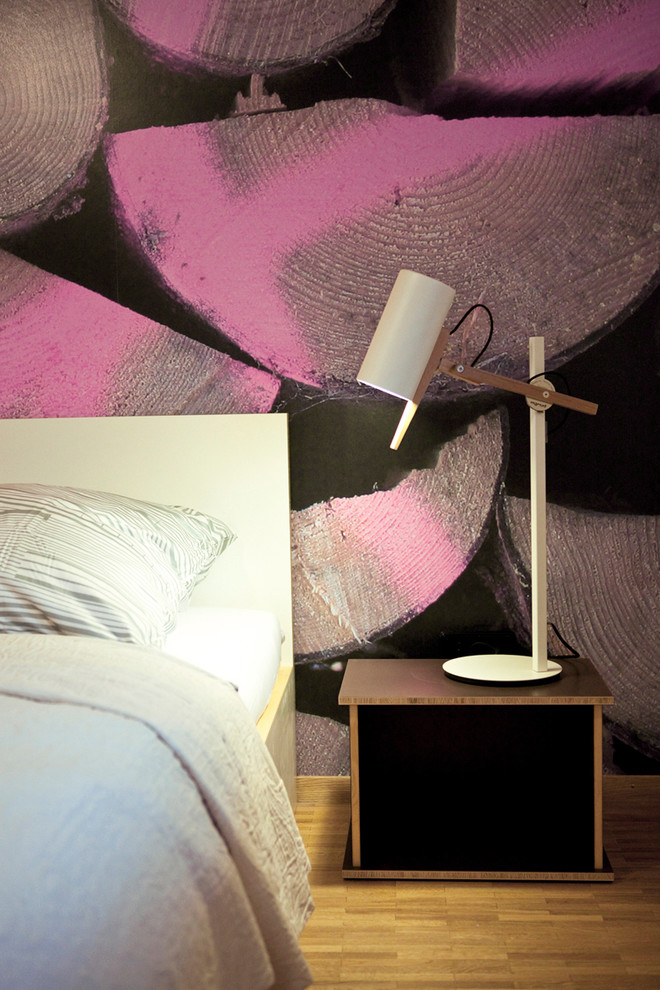 Esempio di una piccola camera matrimoniale minimalista con pareti multicolore e pavimento in legno massello medio