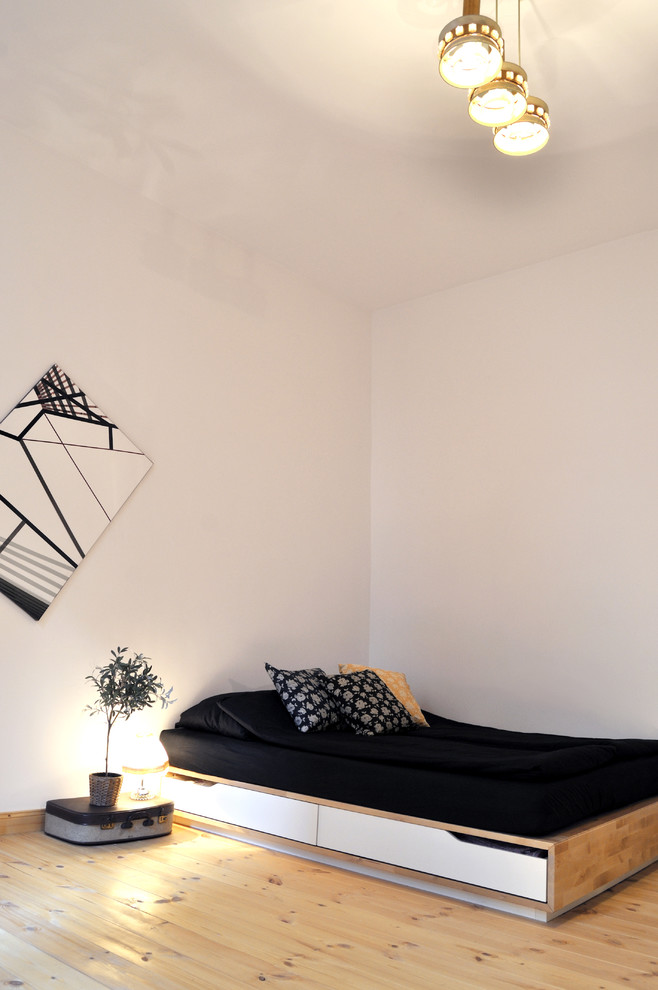 Foto de dormitorio principal escandinavo pequeño con paredes blancas, suelo de madera clara y suelo marrón