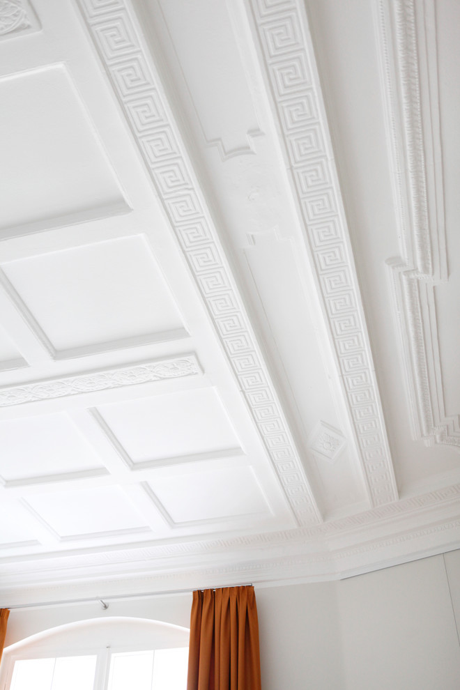 Modelo de habitación de invitados grande con paredes grises, suelo de madera en tonos medios y suelo beige