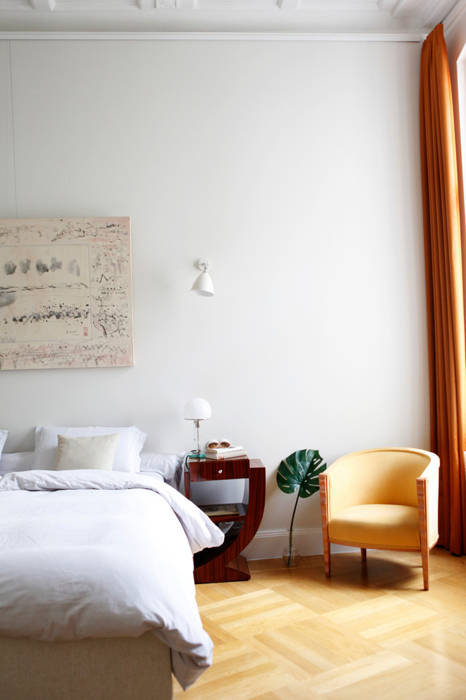 Großes Gästezimmer mit grauer Wandfarbe, braunem Holzboden und beigem Boden in Berlin