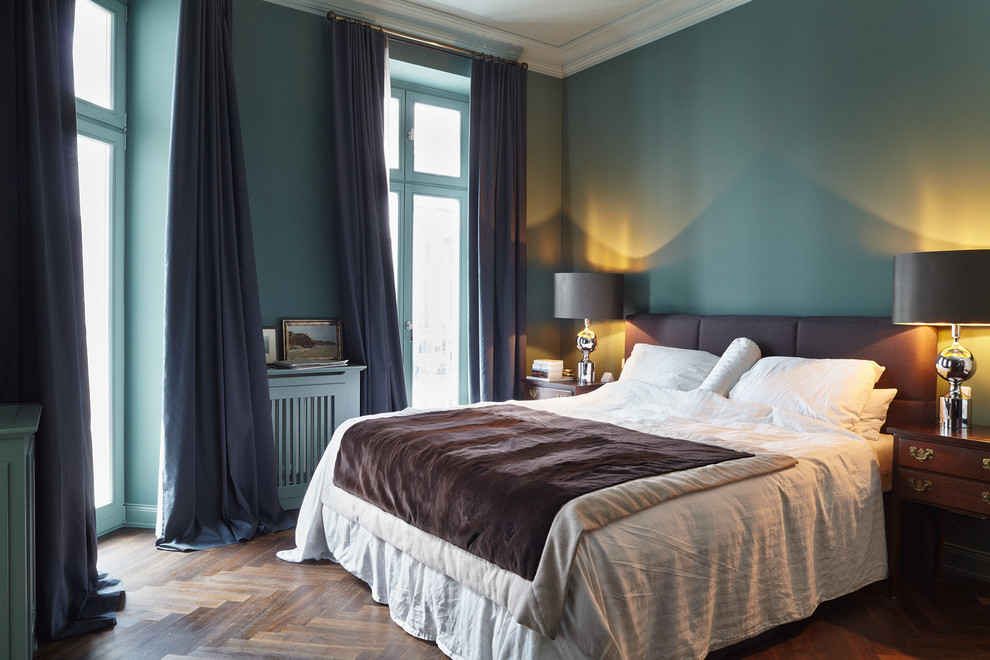 Exemple d'une chambre parentale éclectique de taille moyenne avec un mur bleu, un sol en bois brun et aucune cheminée.