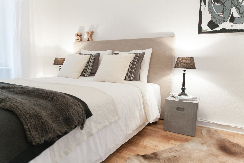 Inspiration för ett mellanstort skandinaviskt sovrum, med vita väggar och mellanmörkt trägolv