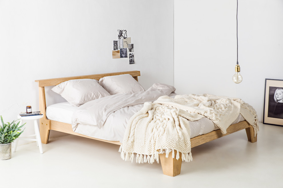 Foto de dormitorio principal escandinavo de tamaño medio sin chimenea con paredes blancas, suelo laminado y suelo blanco