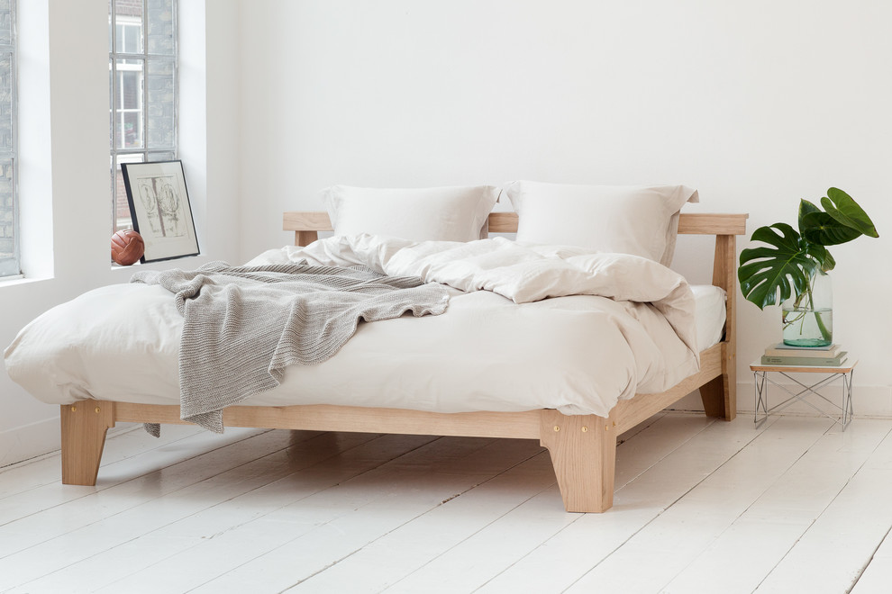 Immagine di una piccola camera matrimoniale minimalista con pareti bianche, pavimento in legno verniciato e pavimento bianco