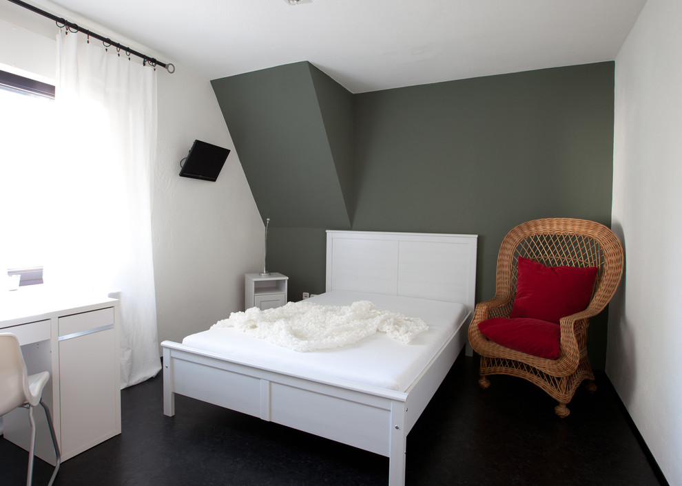 Idée de décoration pour une chambre d'amis minimaliste de taille moyenne avec un mur gris, un sol en vinyl et un sol noir.