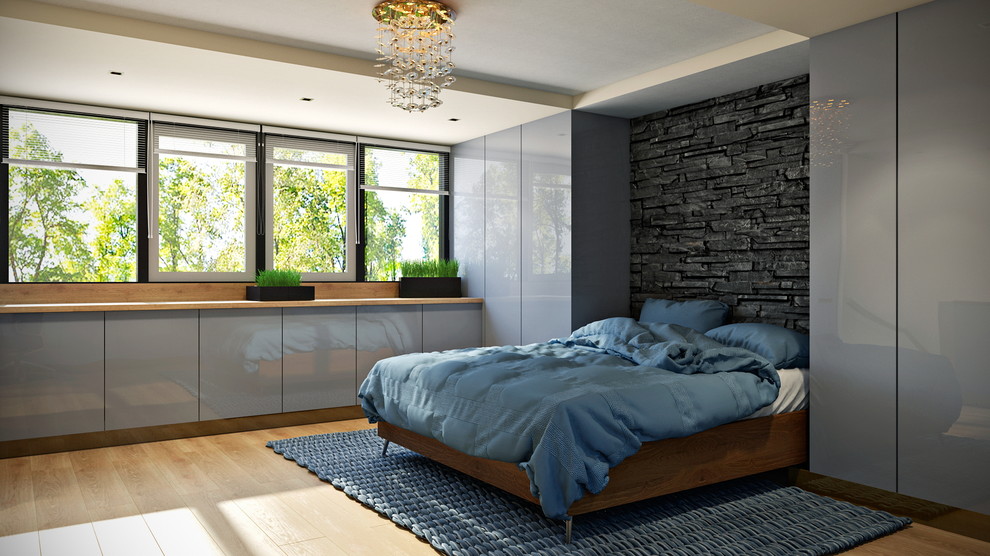 На фото: гостевая спальня среднего размера, (комната для гостей) в современном стиле с серыми стенами, светлым паркетным полом, угловым камином и фасадом камина из дерева