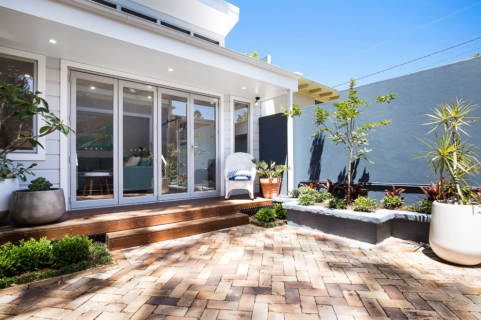 Example of a small beach style detached guesthouse design in Sydney