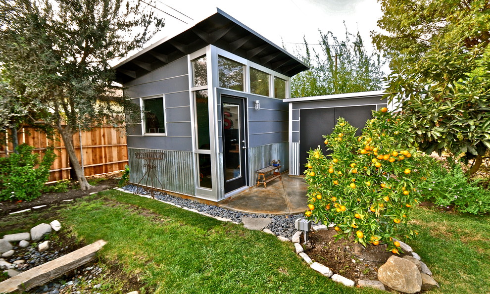 На фото: маленькая отдельно стоящая хозпостройка в современном стиле с мастерской для на участке и в саду