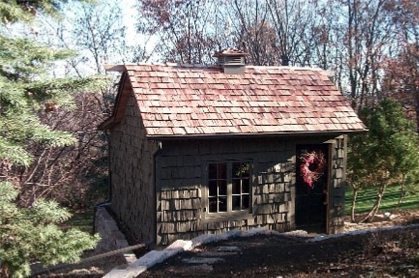 На фото: маленький отдельно стоящий домик для гостей в классическом стиле для на участке и в саду