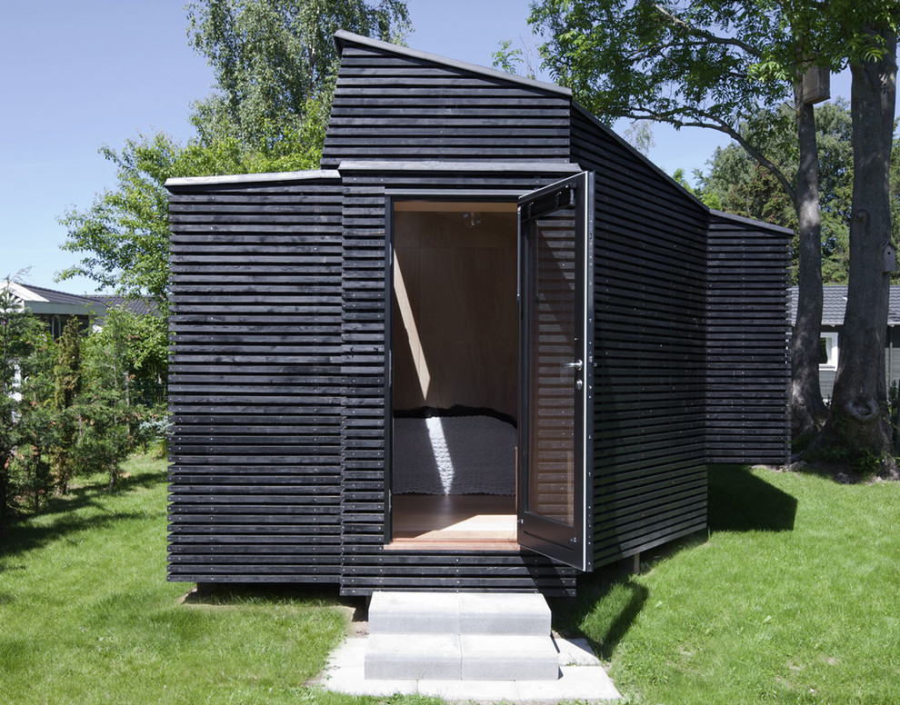 На фото: маленький отдельно стоящий домик для гостей в современном стиле для на участке и в саду с