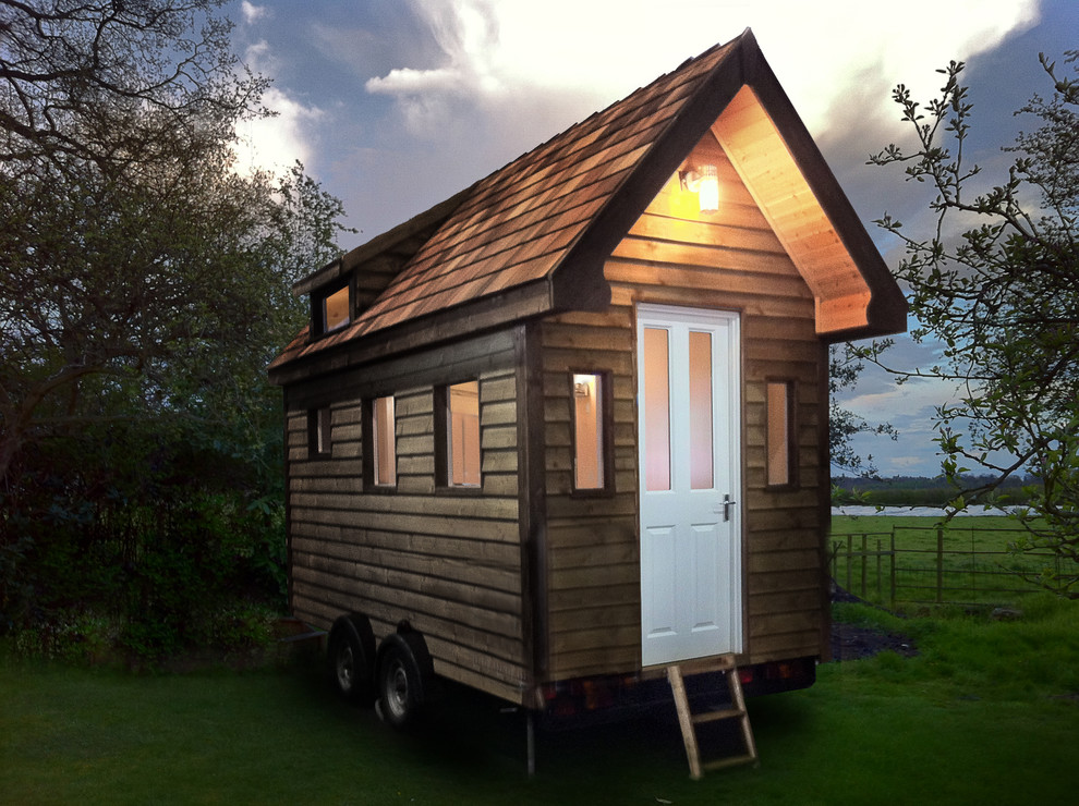 На фото: маленький отдельно стоящий домик для гостей в классическом стиле для на участке и в саду