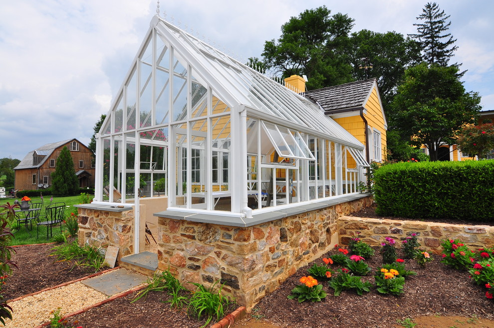 Exempel på en mellanstor klassisk tillbyggd garage och förråd, med växthus