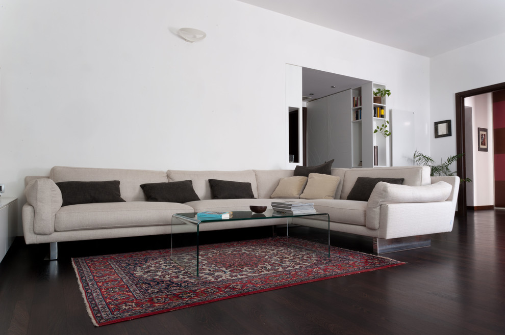 Large trendy open concept dark wood floor living room photo in Milan with white walls