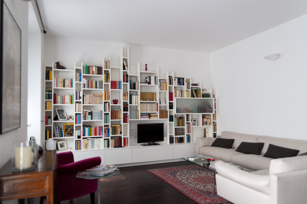 Foto di un grande soggiorno minimalista aperto con libreria, parquet scuro e pareti bianche