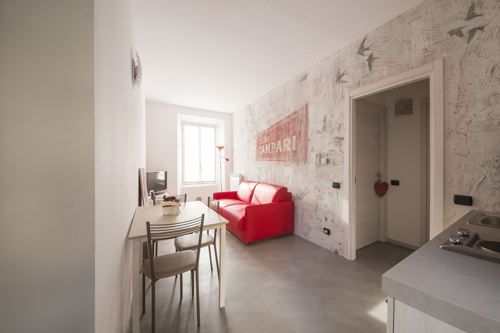 Imagen de salón cerrado actual pequeño sin chimenea con paredes multicolor, suelo de cemento, televisor independiente y suelo gris