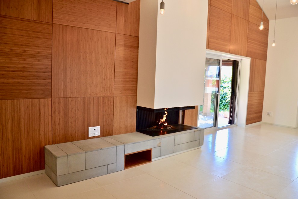 На фото: большая открытая гостиная комната в современном стиле с белыми стенами, бетонным полом, горизонтальным камином, телевизором на стене и белым полом с