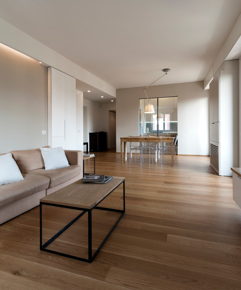 Foto de salón abierto moderno grande con paredes grises y suelo de madera clara
