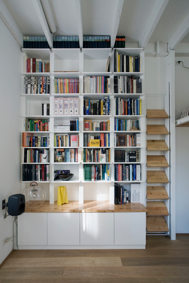 Moderne Bibliothek mit weißer Wandfarbe und braunem Holzboden in Mailand
