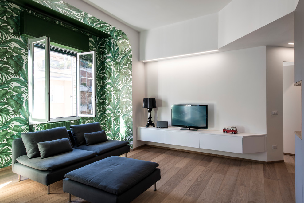 Modelo de sala de estar abierta contemporánea de tamaño medio con paredes multicolor, suelo de madera en tonos medios y televisor independiente