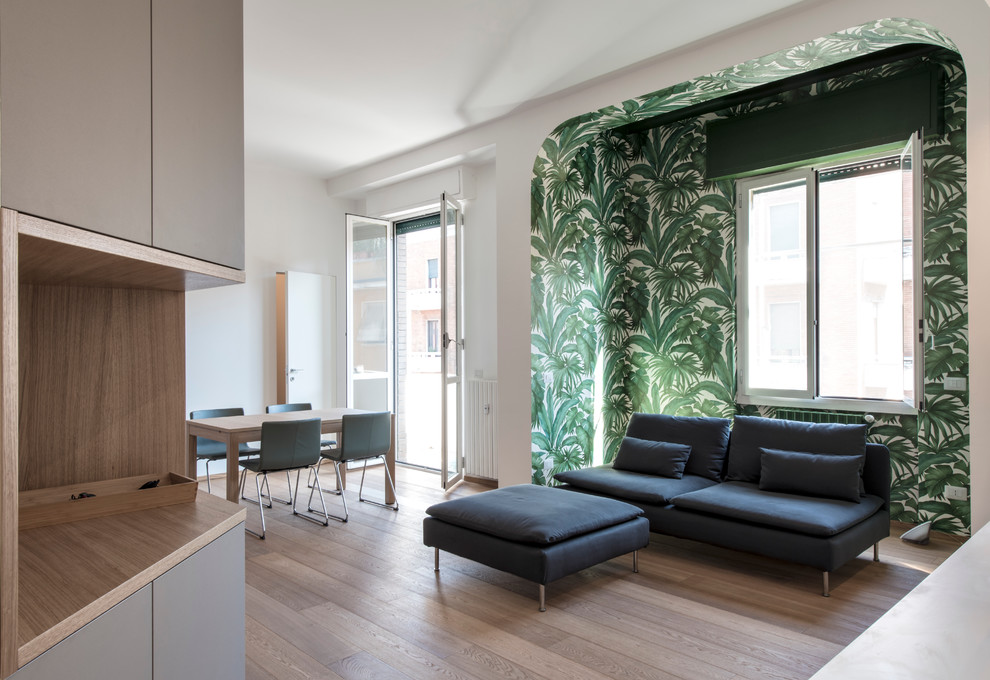 Imagen de sala de estar abierta actual de tamaño medio con paredes verdes y suelo de madera clara