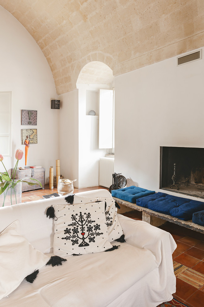На фото: гостиная комната в средиземноморском стиле с полом из терракотовой плитки