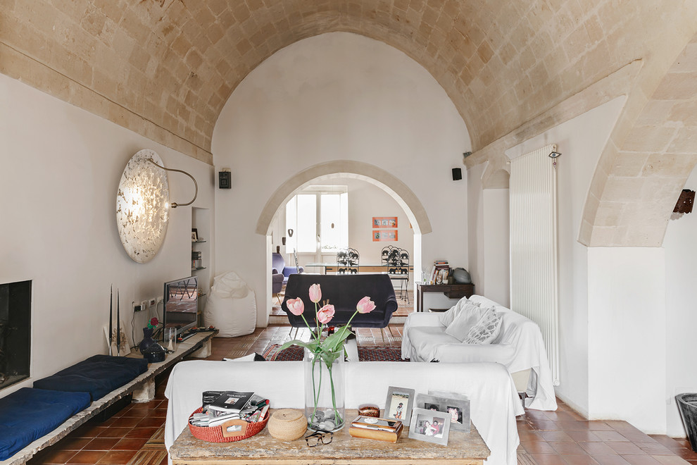 Immagine di un soggiorno mediterraneo di medie dimensioni e aperto con pavimento in terracotta e pareti bianche