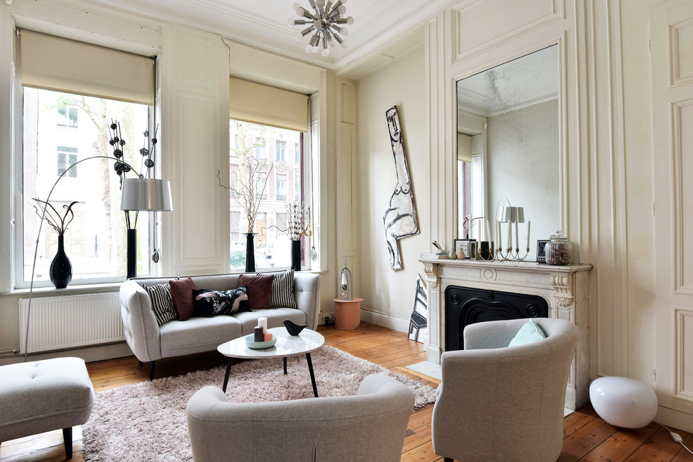 Modernes Wohnzimmer mit beiger Wandfarbe, hellem Holzboden, Kamin und Kaminumrandung aus Stein in Lille