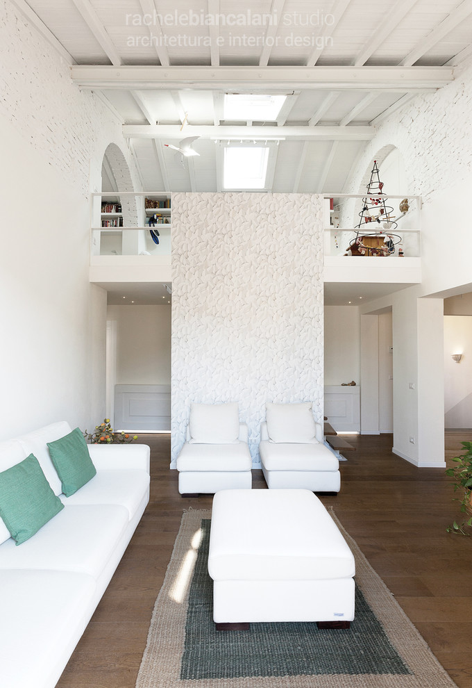 フィレンツェにある高級な広い北欧スタイルのおしゃれなオープンリビング (ライブラリー、白い壁、淡色無垢フローリング、壁掛け型テレビ、茶色い床) の写真